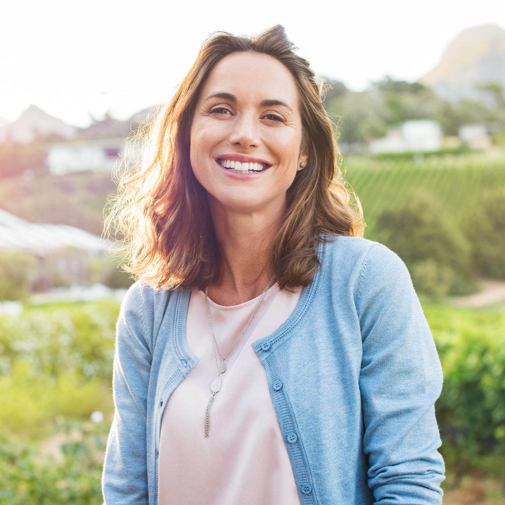 a woman in a blue shirt and smiling at the camera