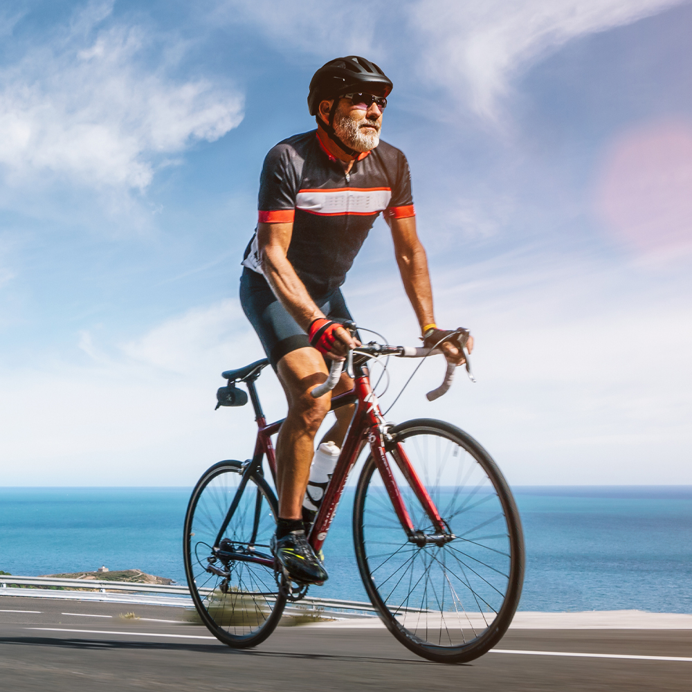a man riding a bicycle next to a body of water