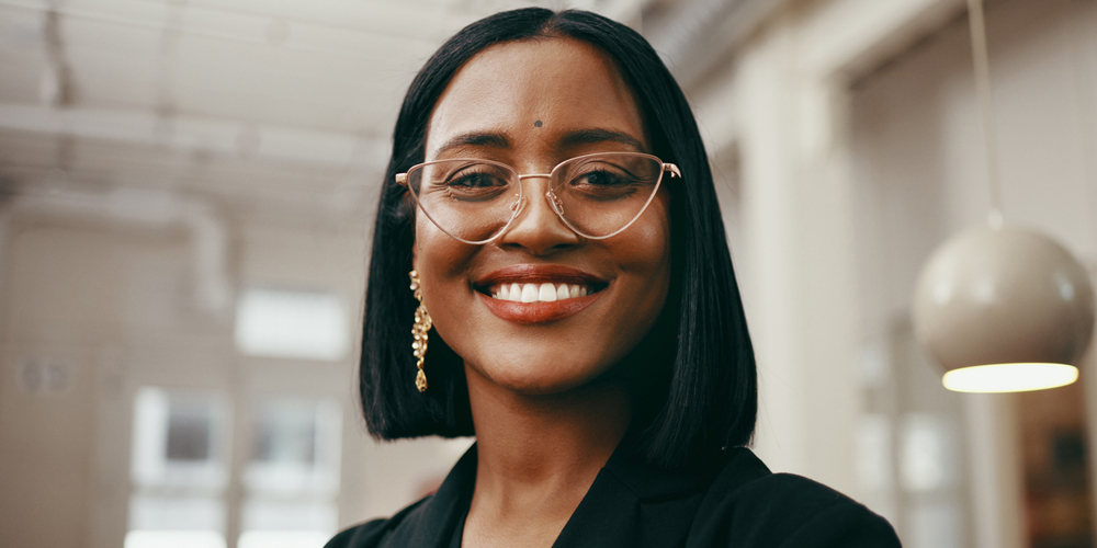 a woman wearing glasses and smiling at the camera