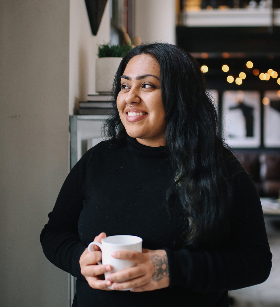 Emem Isong holding a cup of coffee