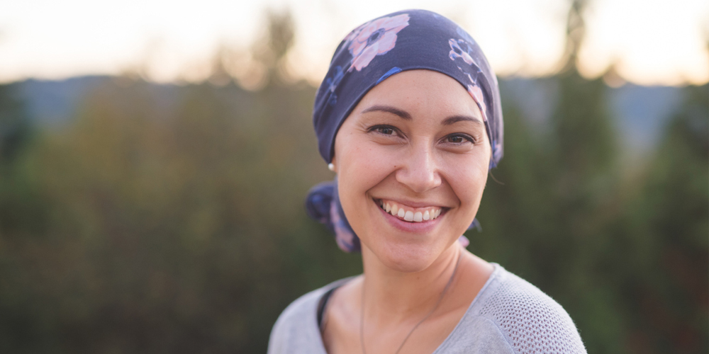 a woman wearing a hat and smiling at the camera