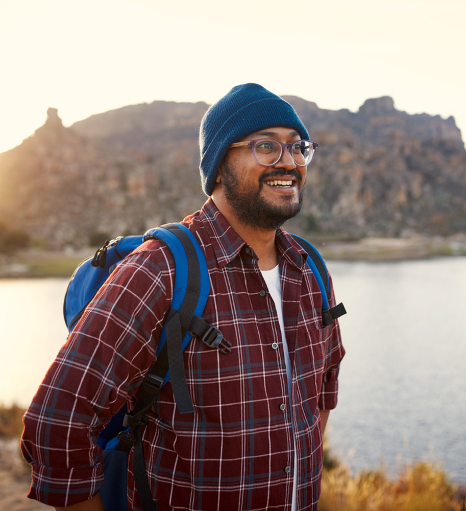 a man standing next to a body of water